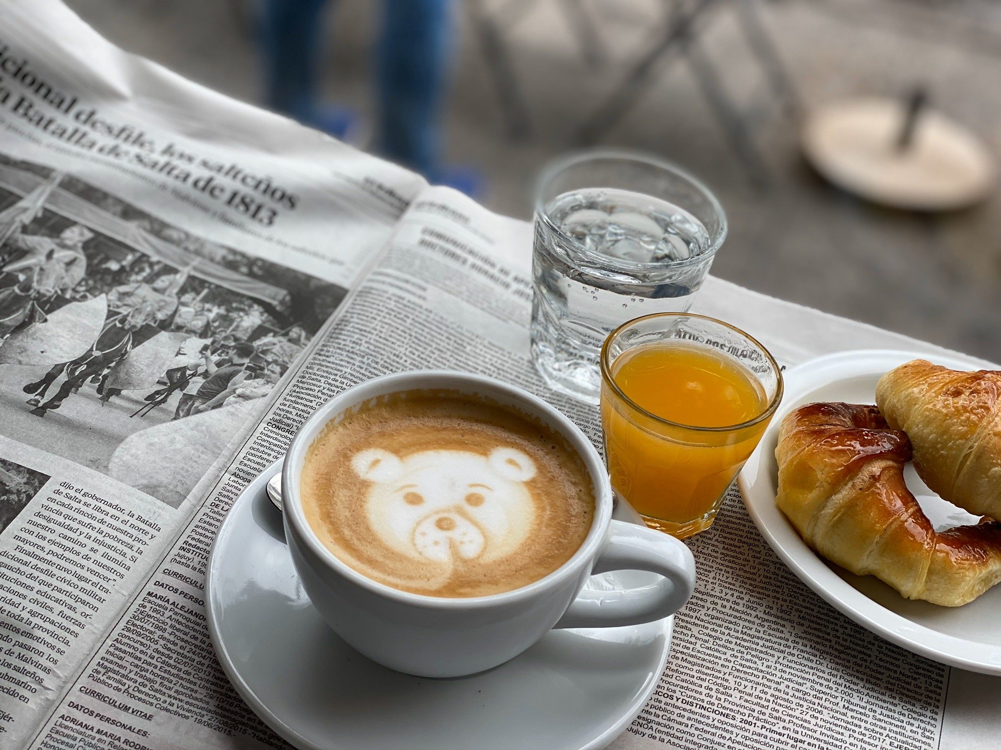 Cappuccino con latte art en forma de oso, croissant y jugo en Bici Café Salta